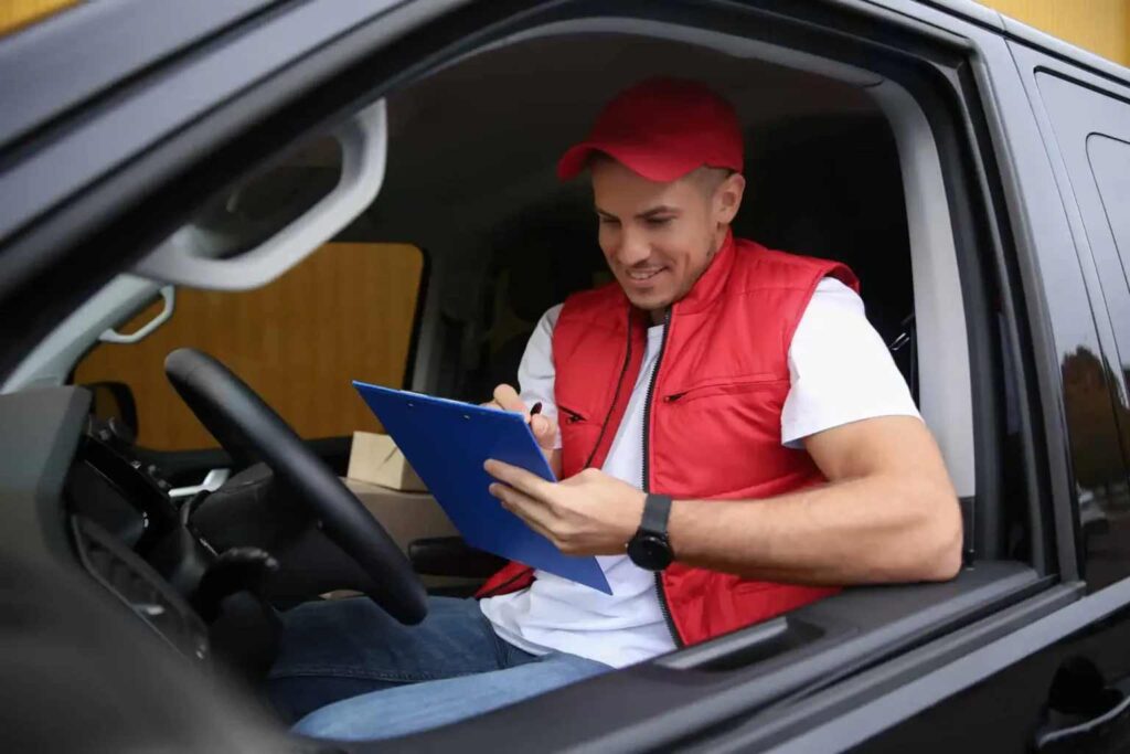 man filling a document inside a car