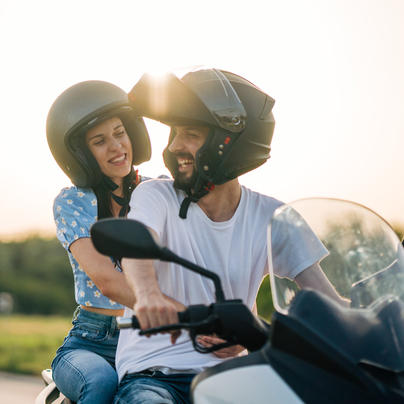 a couple riding a motorcycle with helmets